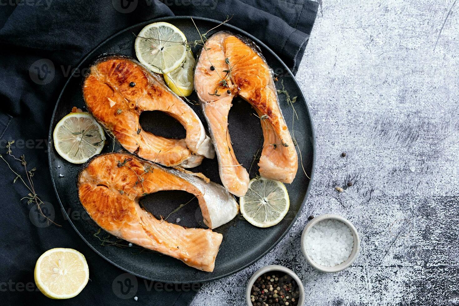 Stake Fish trout with lemon and spices on dark background photo