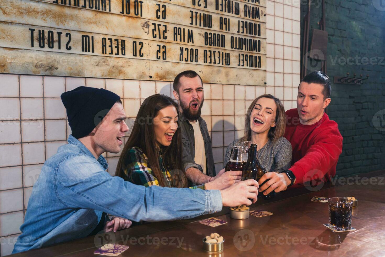 Group of young beautiful friends watching TV and cheering for th photo