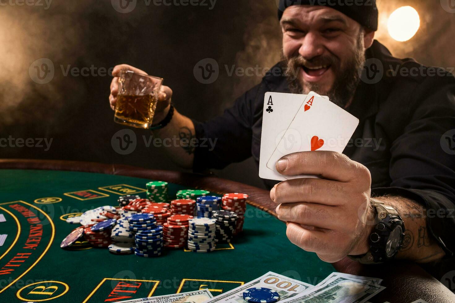 Bearded man showing poker cards on black background photo