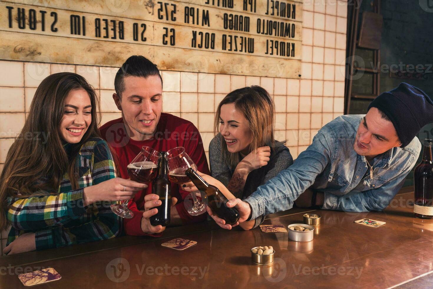 Watching TV in pub. Happy young friends are cheering for team an photo
