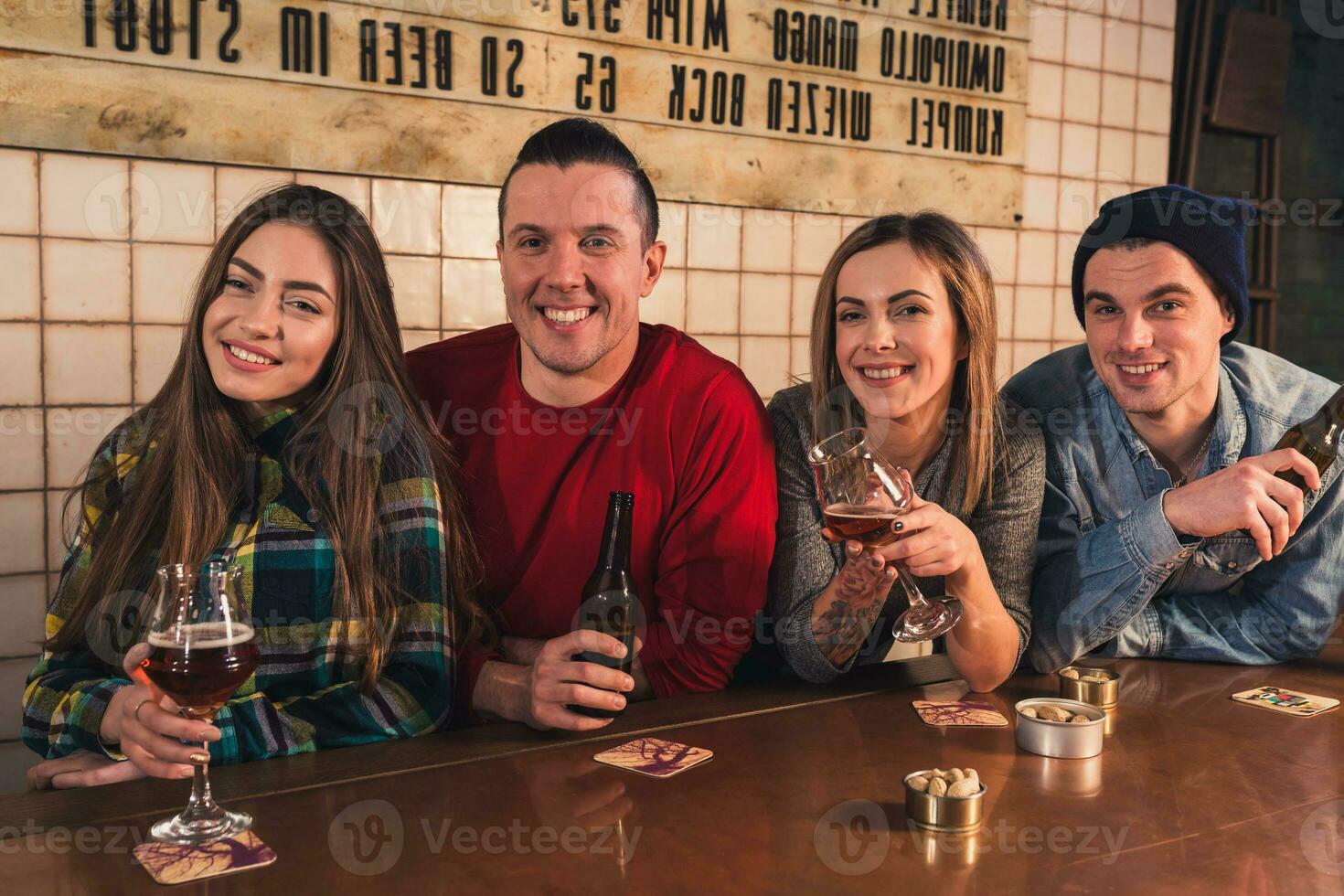 Watching TV in pub. Happy young friends are cheering for team an photo