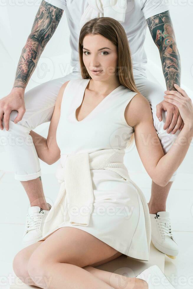 Portrait of a beautiful woman sitting on a chair and holding the hand of a man photo