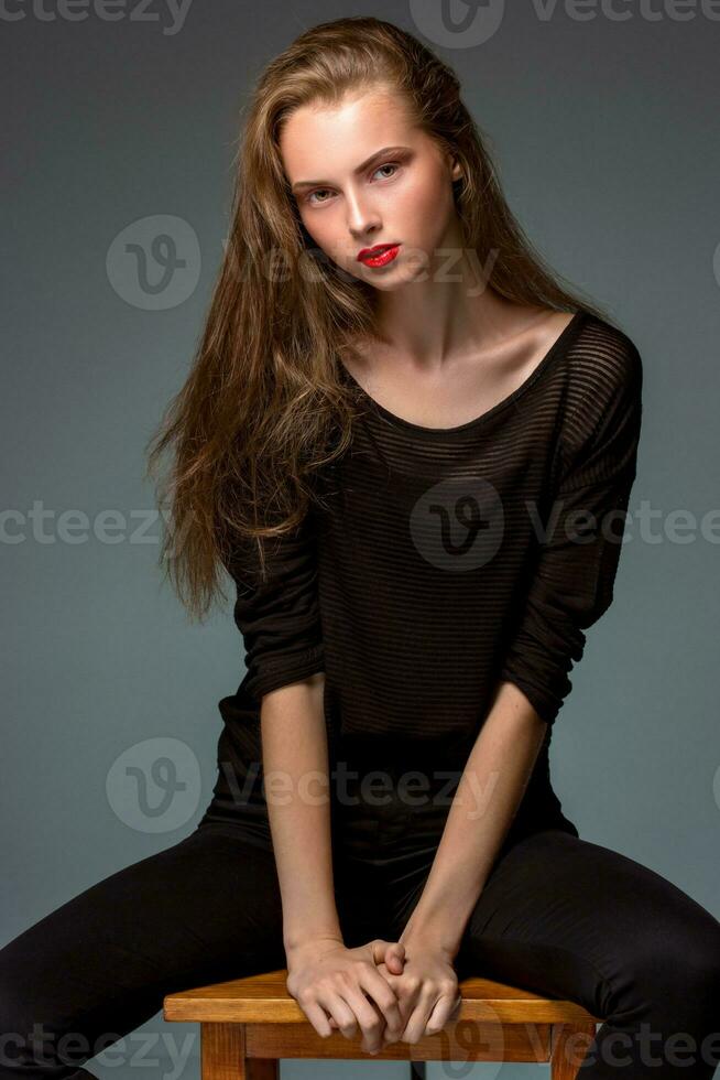 Portrait beauty woman sitting on a chair isolated black background. photo