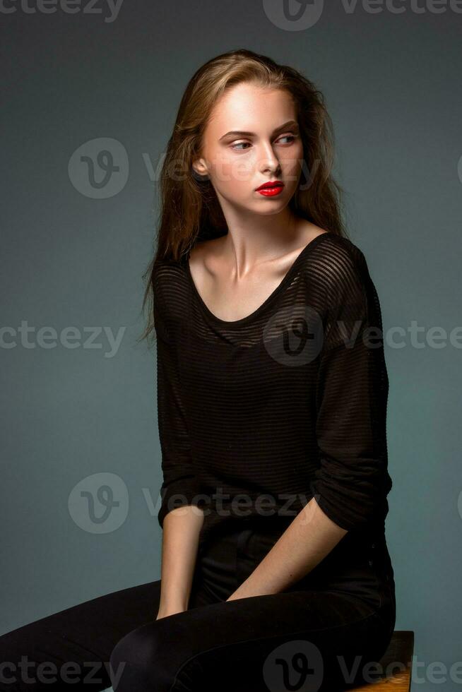 Portrait beauty woman sitting on a chair isolated black background. photo