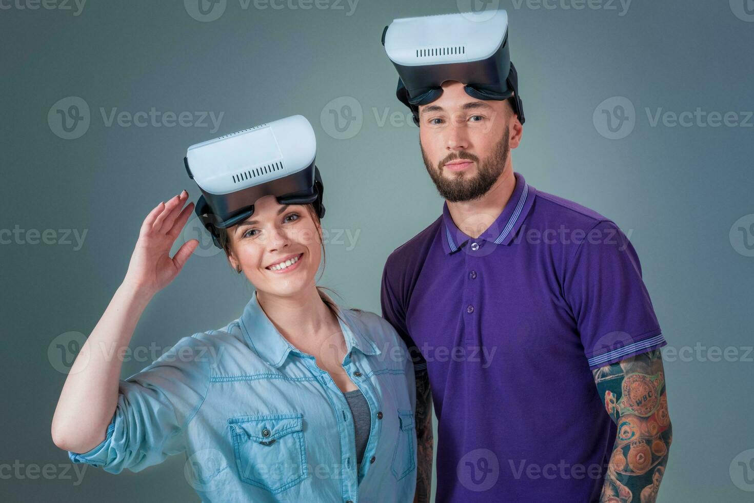 Excited young man and woman having fun with a VR glasses photo