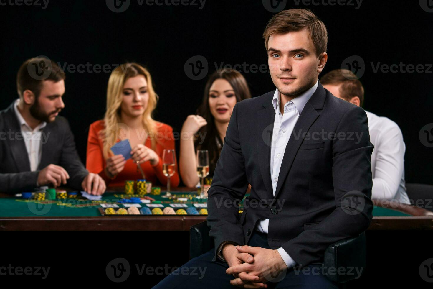 Young people playing poker at the table. Casino photo