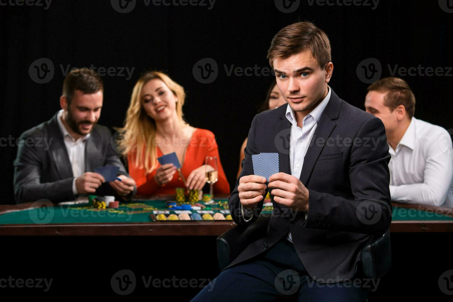 Young people playing poker at the table. Casino photo