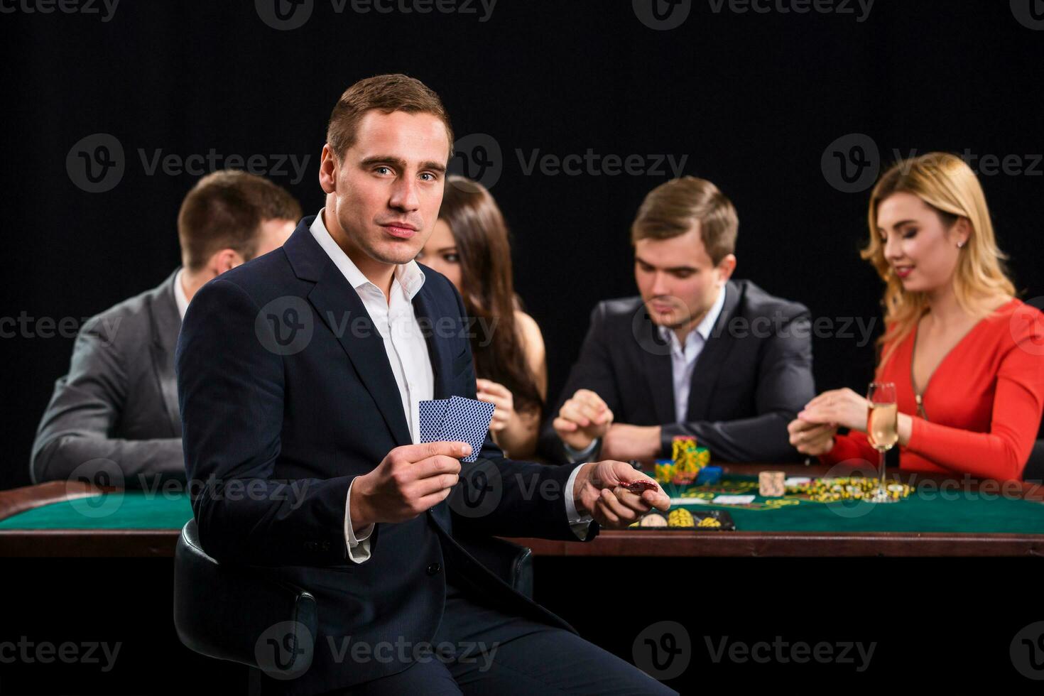 Poker players in casino with cards and chips on black background photo