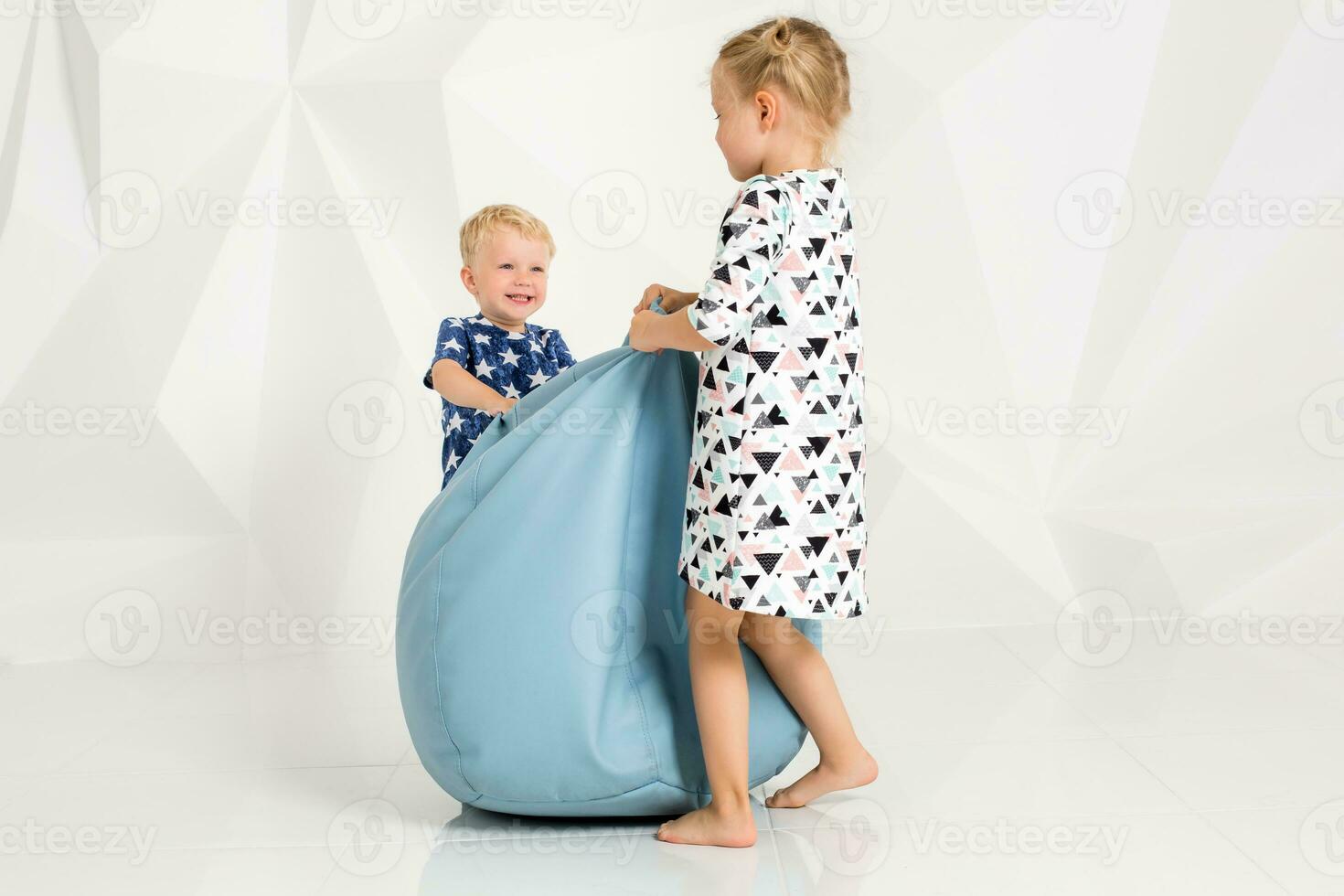 hermano y hermana jugando y sonriente en un blanco estudio foto