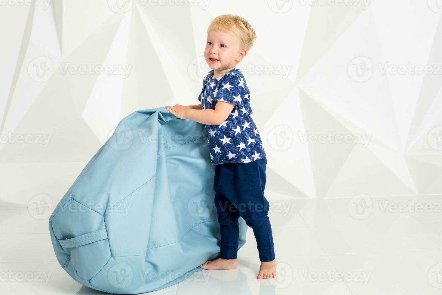 little boy in a t-shirt and shorts on a white background photo