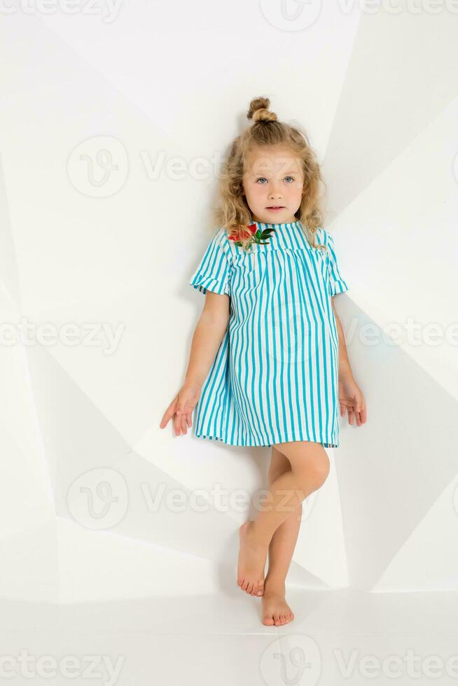 Beautiful little fashion model on white studio background. Portrait of cute girl posing in studio photo