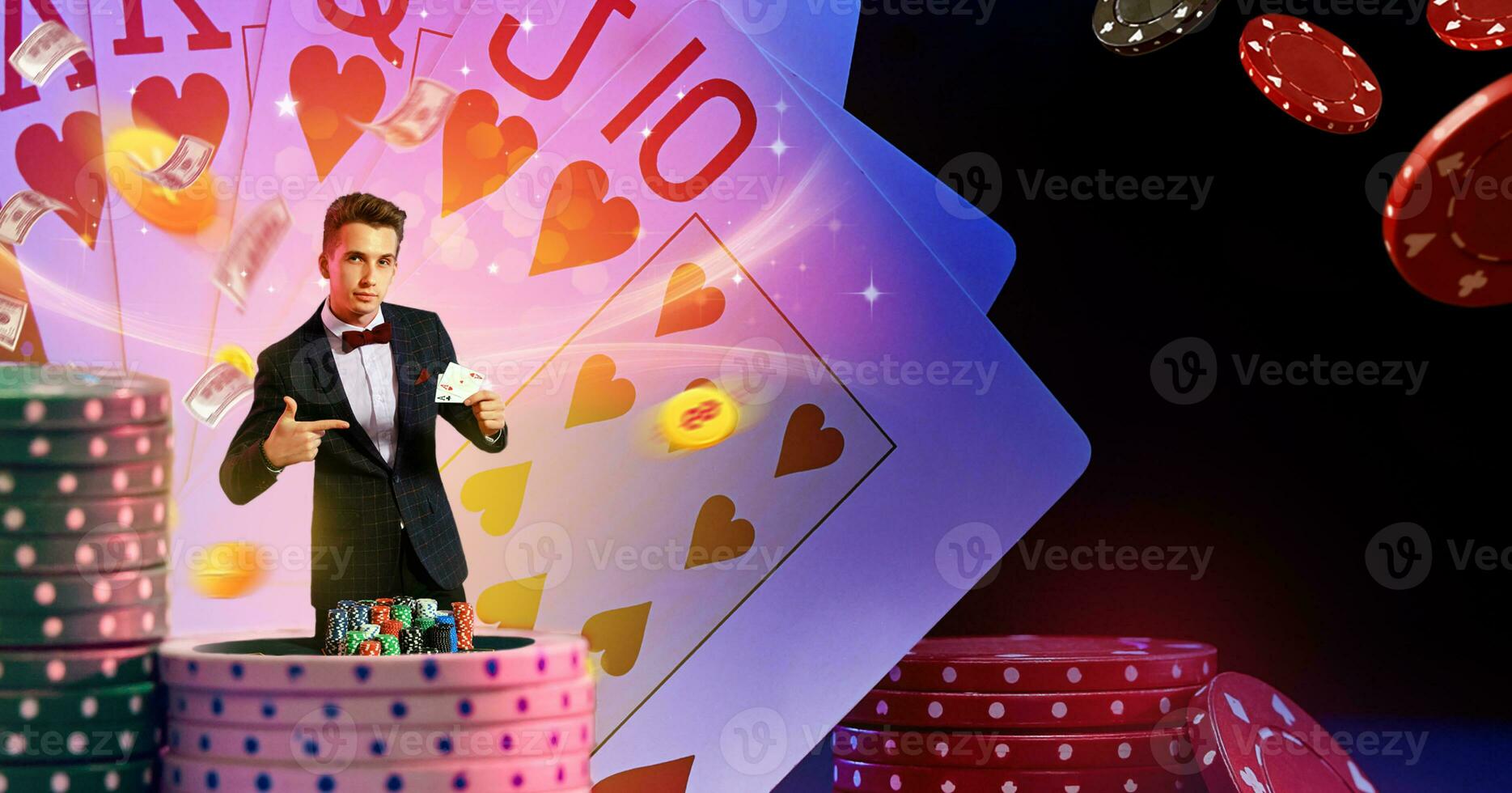 Man in suit pointing at two aces in his hand, posing against background with flying dollars and coins, playing cards, stacks of chips. Poker, casino photo