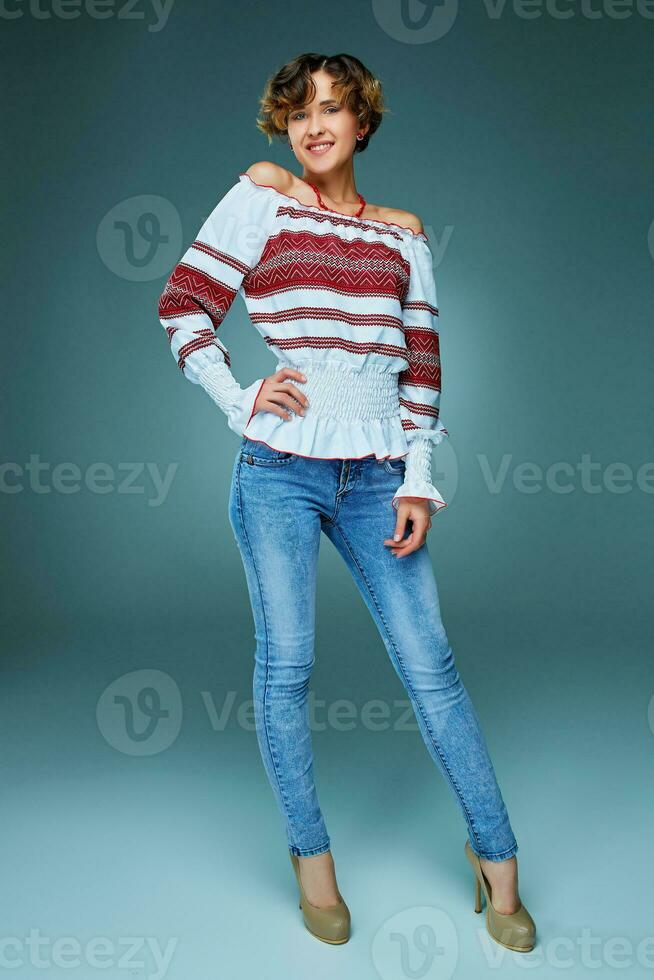 Portrait of charming young lady with short hair in embroide photo