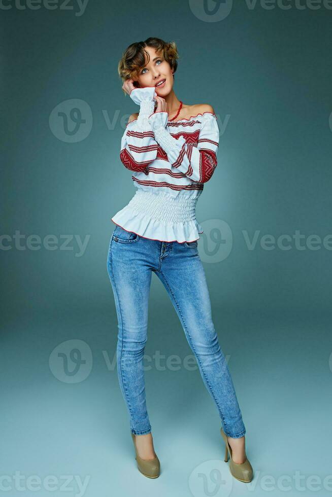 Portrait of charming young lady with short hair in embroide photo