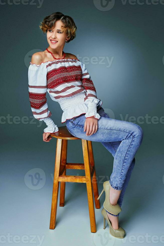 Portrait charming young lady with short wavy hair in embroidery. photo