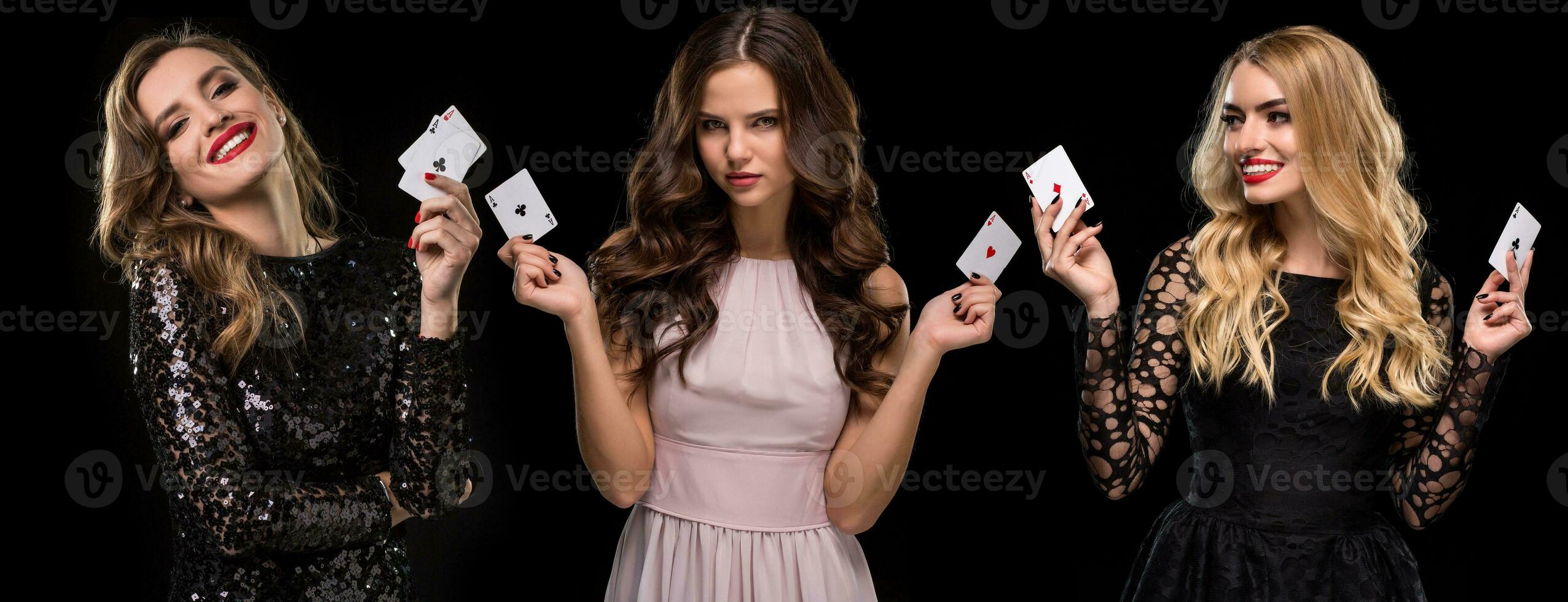 Three females in stylish dresses and jewelry. They are smiling, holding aces in their hands, posing on black background. Poker, casino. Close-up photo