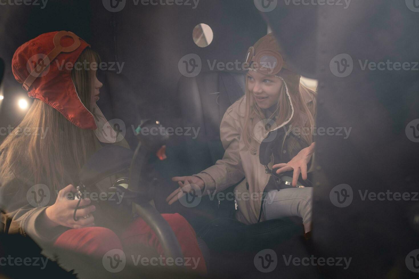 Emotional preteen girl talking to female friend in helicopter cockpit photo