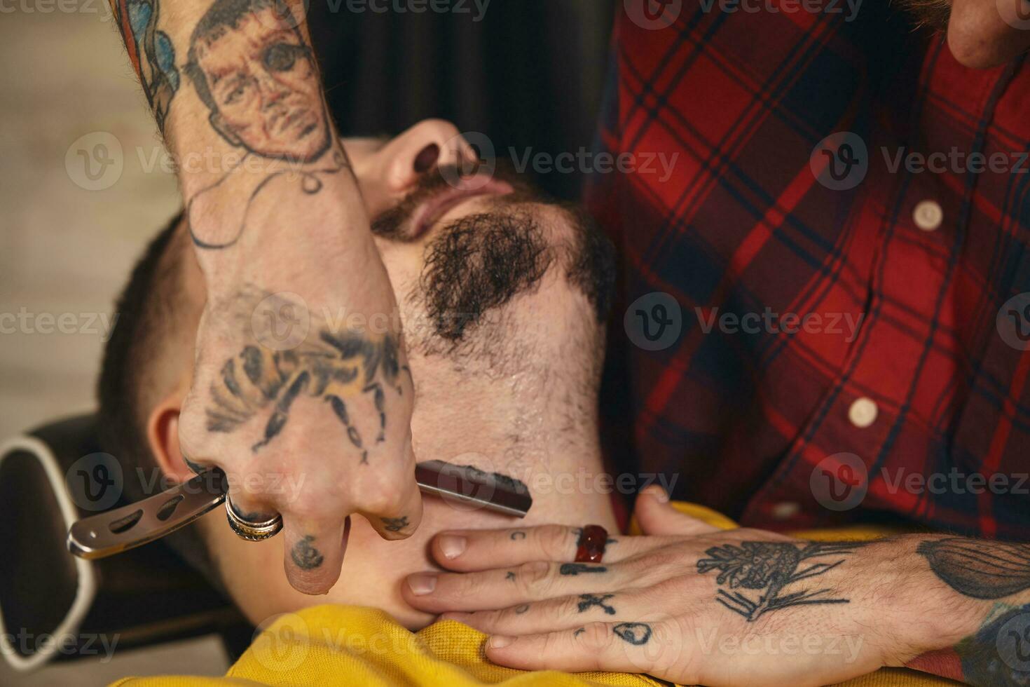 Client during beard shaving in barber shop photo