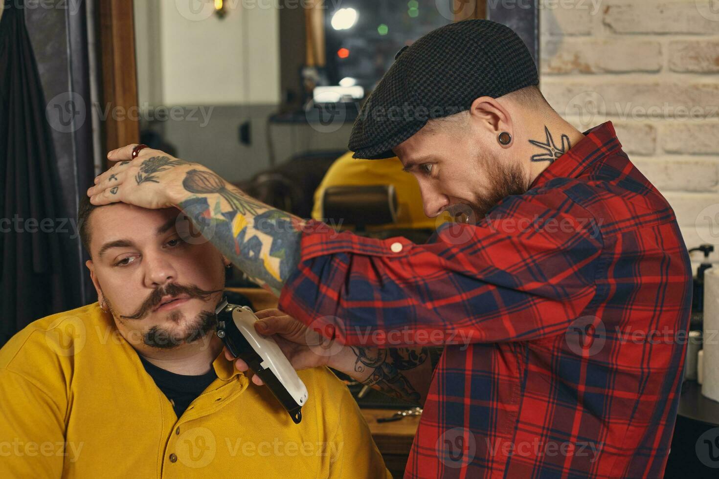 Client during beard shaving in barber shop photo