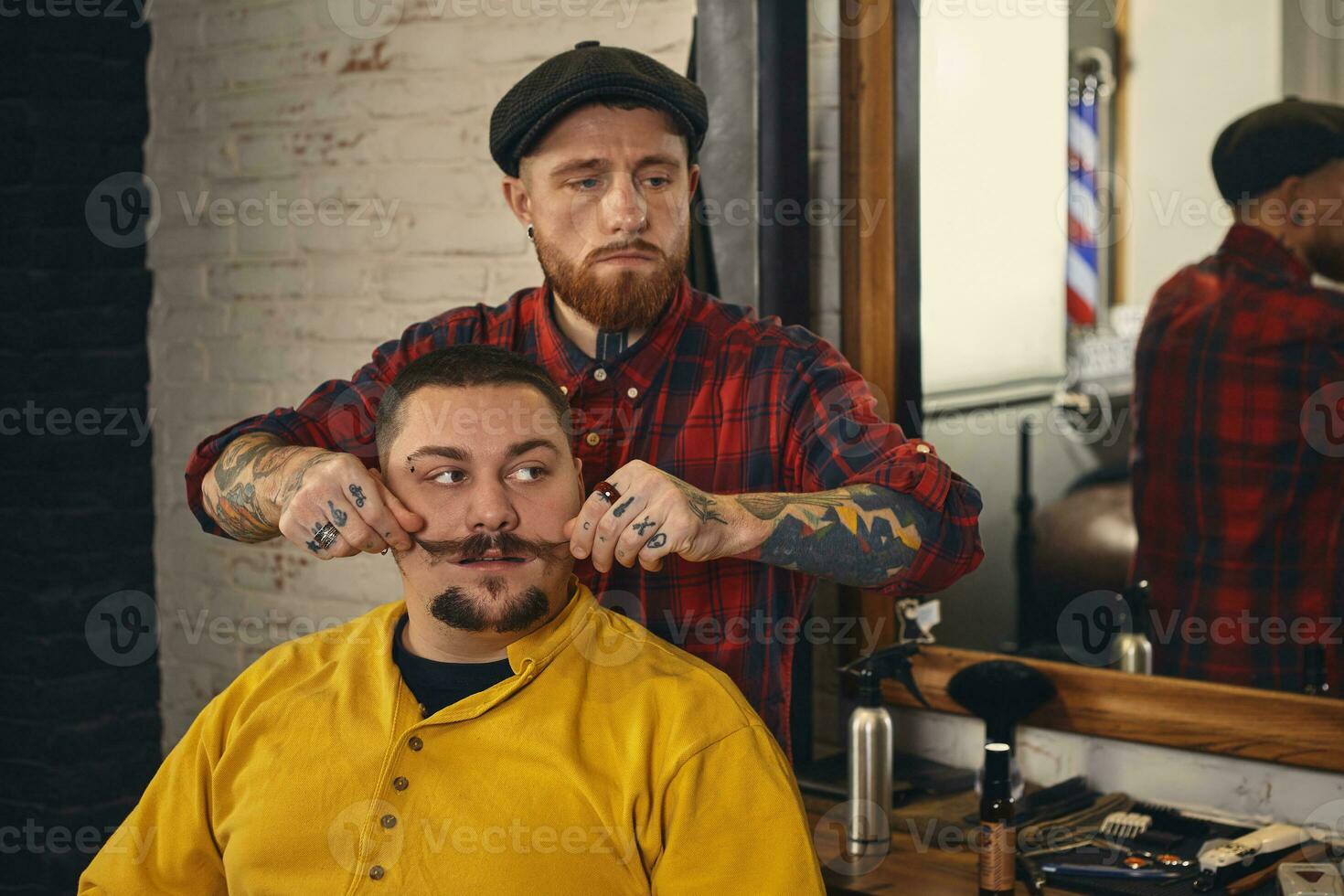 Client during beard shaving in barber shop photo