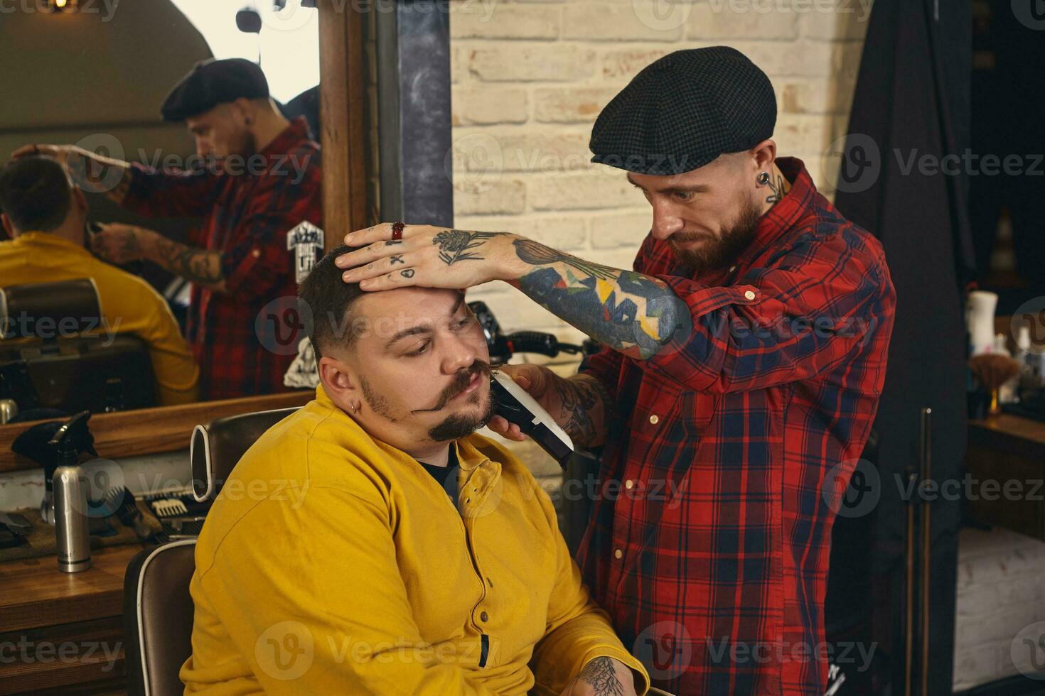 Client during beard shaving in barber shop photo