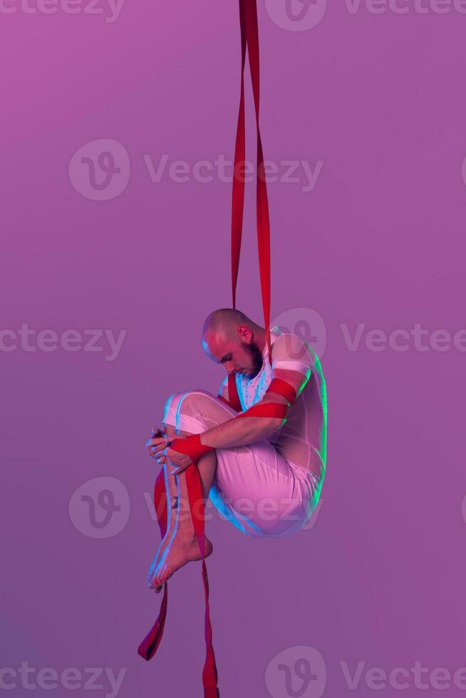 atlético hombre en un blanco deporte traje es ejecutando un acrobático elementos en un estudio. foto