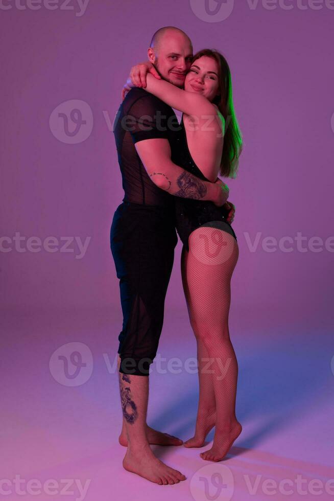 Athletic gymnasts in a black sport suits are posing in a studio. photo