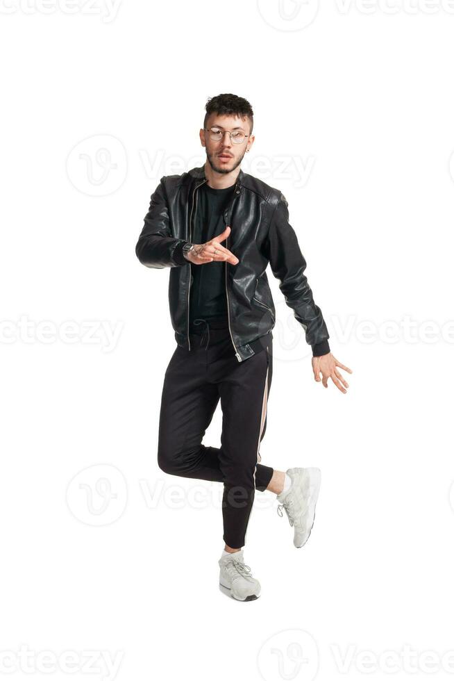 Full-length photo of a funny guy dancing in studio isolated on white background.