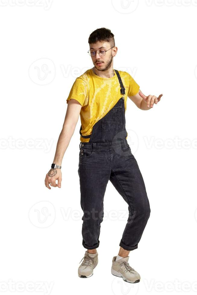 Full-length portrait of a funny guy dancing in studio isolated on white background. photo