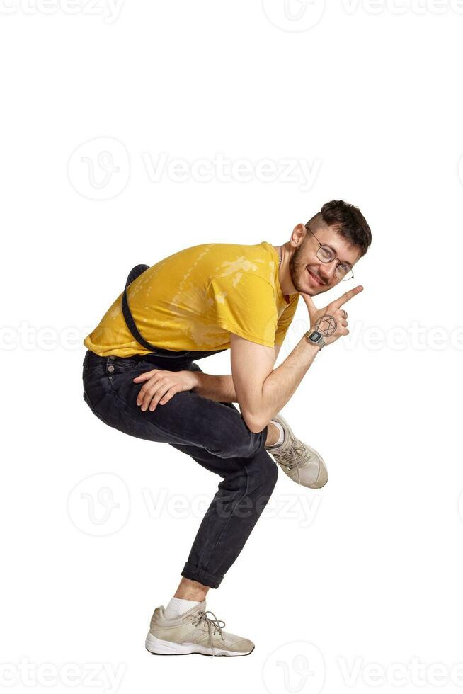 Full-length portrait of a funny guy dancing in studio isolated on white background. photo