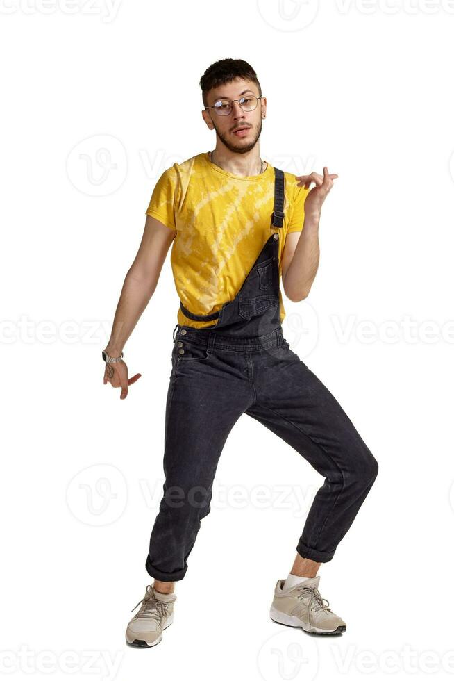 Full-length portrait of a funny guy dancing in studio isolated on white background. photo