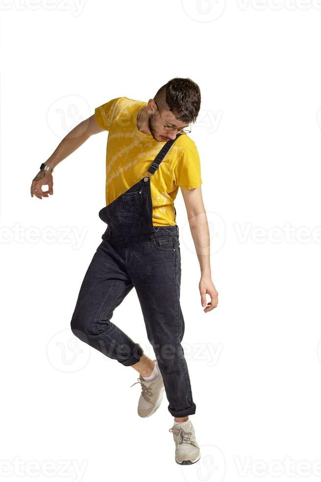 Full-length portrait of a funny guy dancing in studio isolated on white background. photo