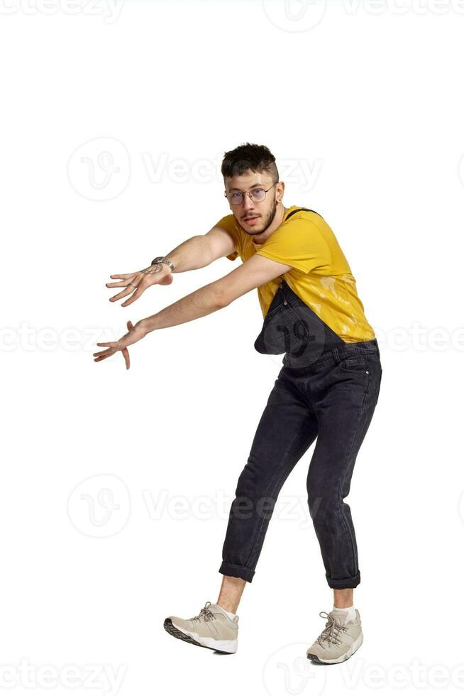 Full-length portrait of a funny guy dancing in studio isolated on white background. photo