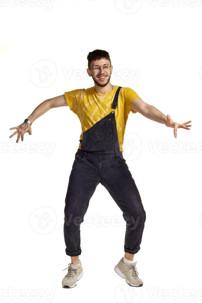 Full-length portrait of a funny guy dancing in studio isolated on white background. photo