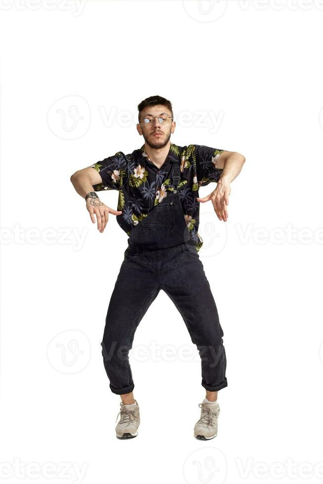 Full-length portrait of a funny guy dancing in studio isolated on white background. photo