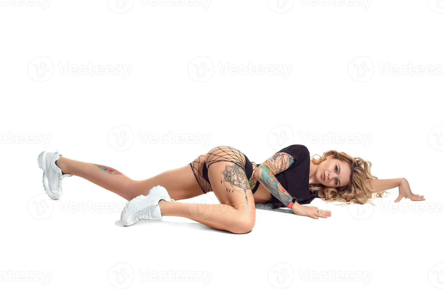 beautiful blonde girl in booty shorts and fishnet dancing twerk isolated on white background photo