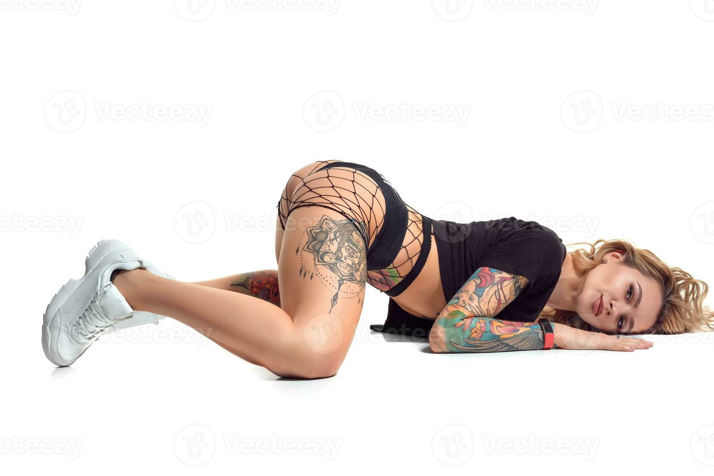 beautiful blonde girl in booty shorts and fishnet dancing twerk isolated on white background photo