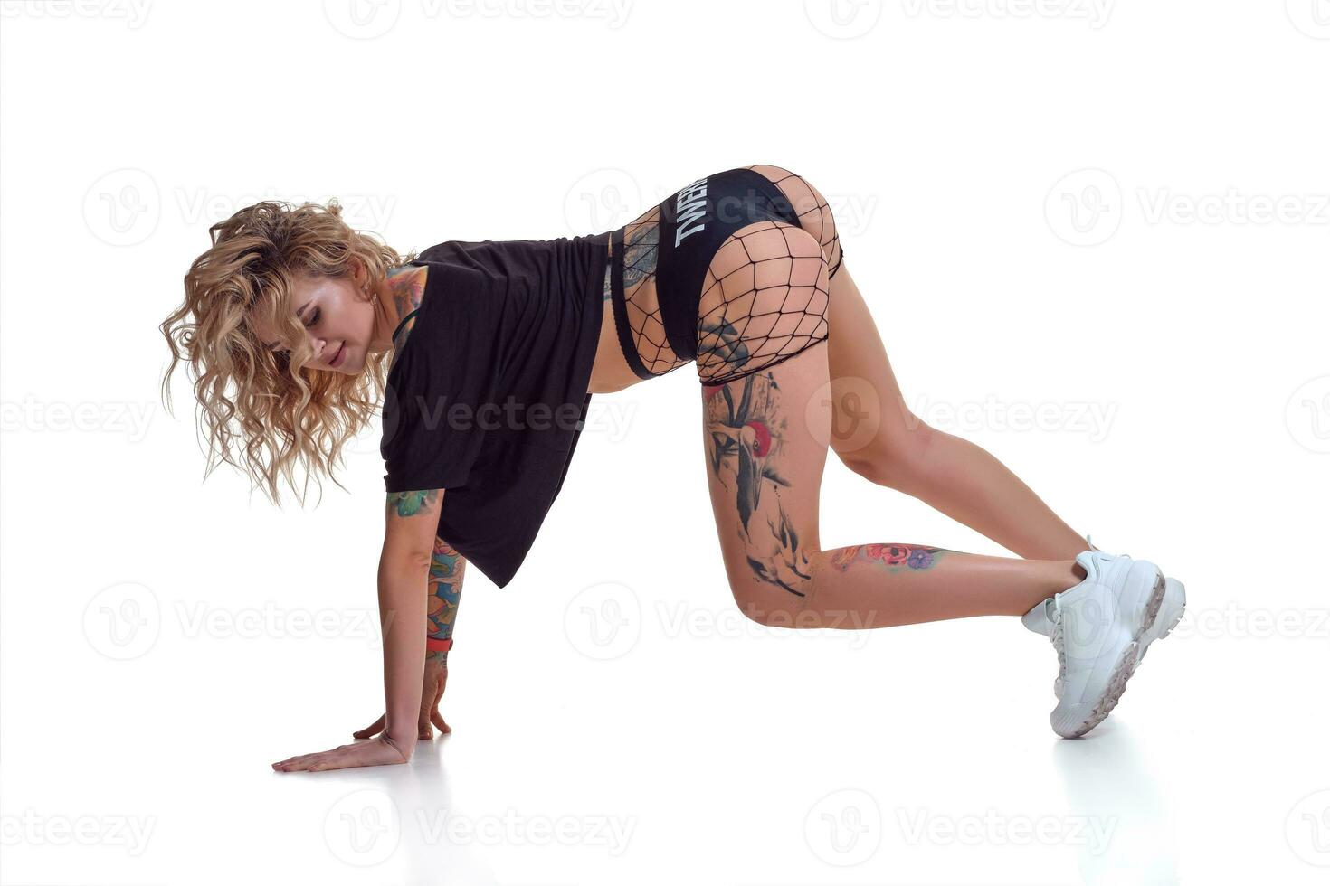 beautiful blonde girl in booty shorts and fishnet dancing twerk isolated on white background photo
