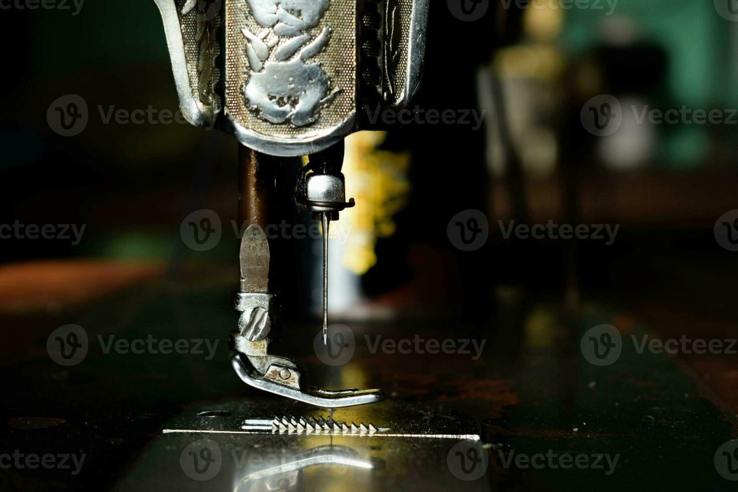 Close up sewing machine with needle on wood table, antique sewing machine with dust photo