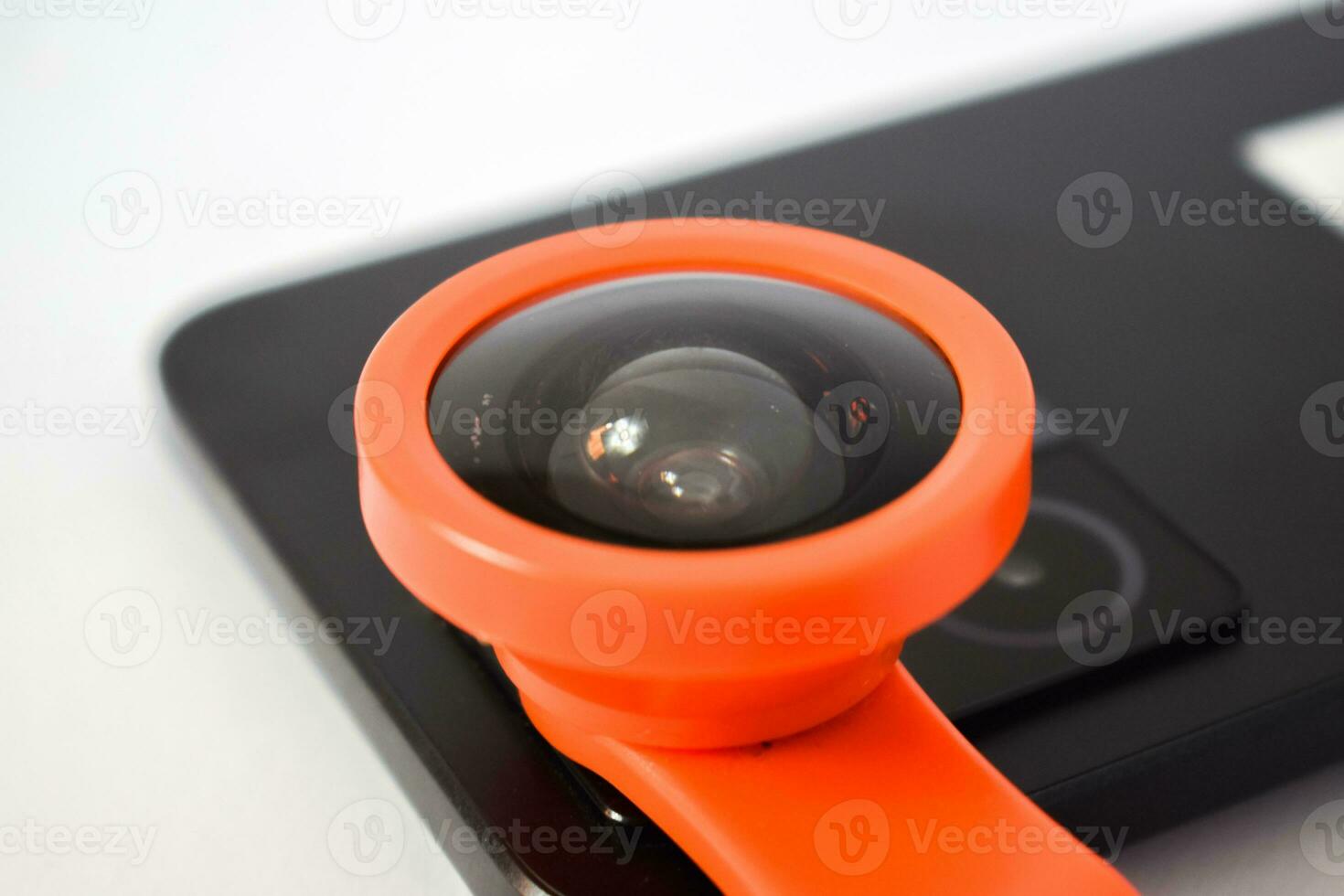 Close up Clip on fisheye lens on black smartphone, extension fish eye lens on smartphone  camera isolated on white background photo