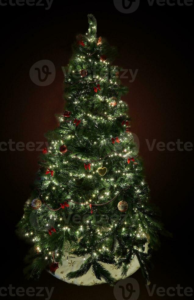 Christmas tree with decorations and garlands with lights on a dark background photo