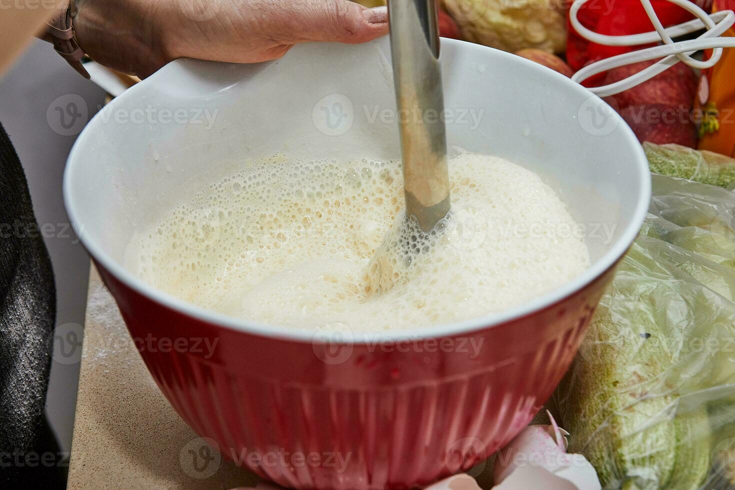 Homemaker Whisking Pancake Batter in Kitchen with Blender and Bowl photo