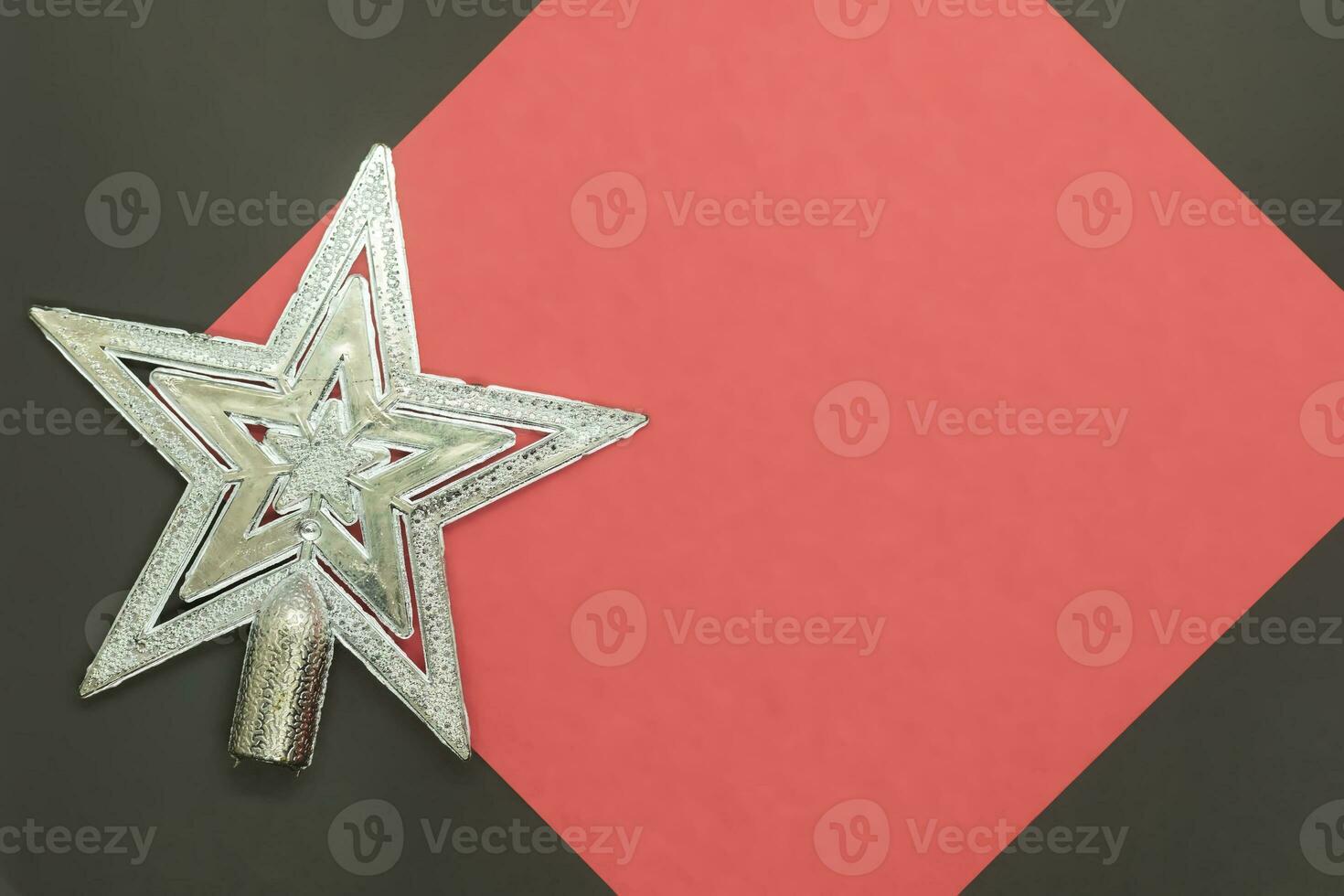 Christmas silver star on a red and black background with copy space photo