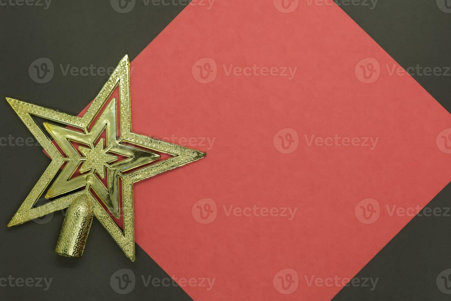 Christmas golden star on red paper with copy space for text on black background photo