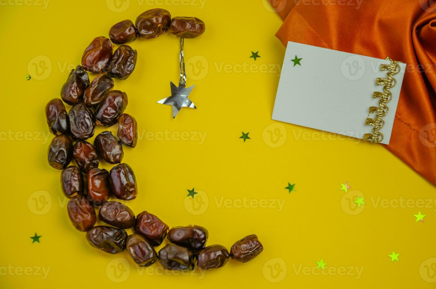 Ramadan holiday concept, on a yellow background of dates in the form of a moon with shiny stars. High quality photo