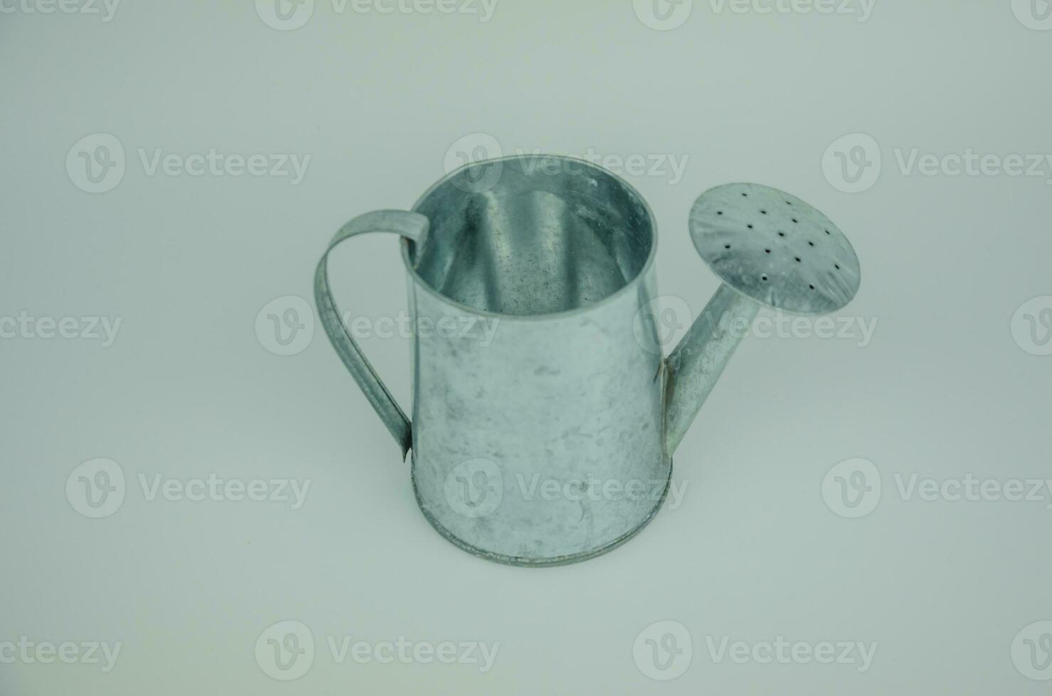 one metal watering can on a light background photo