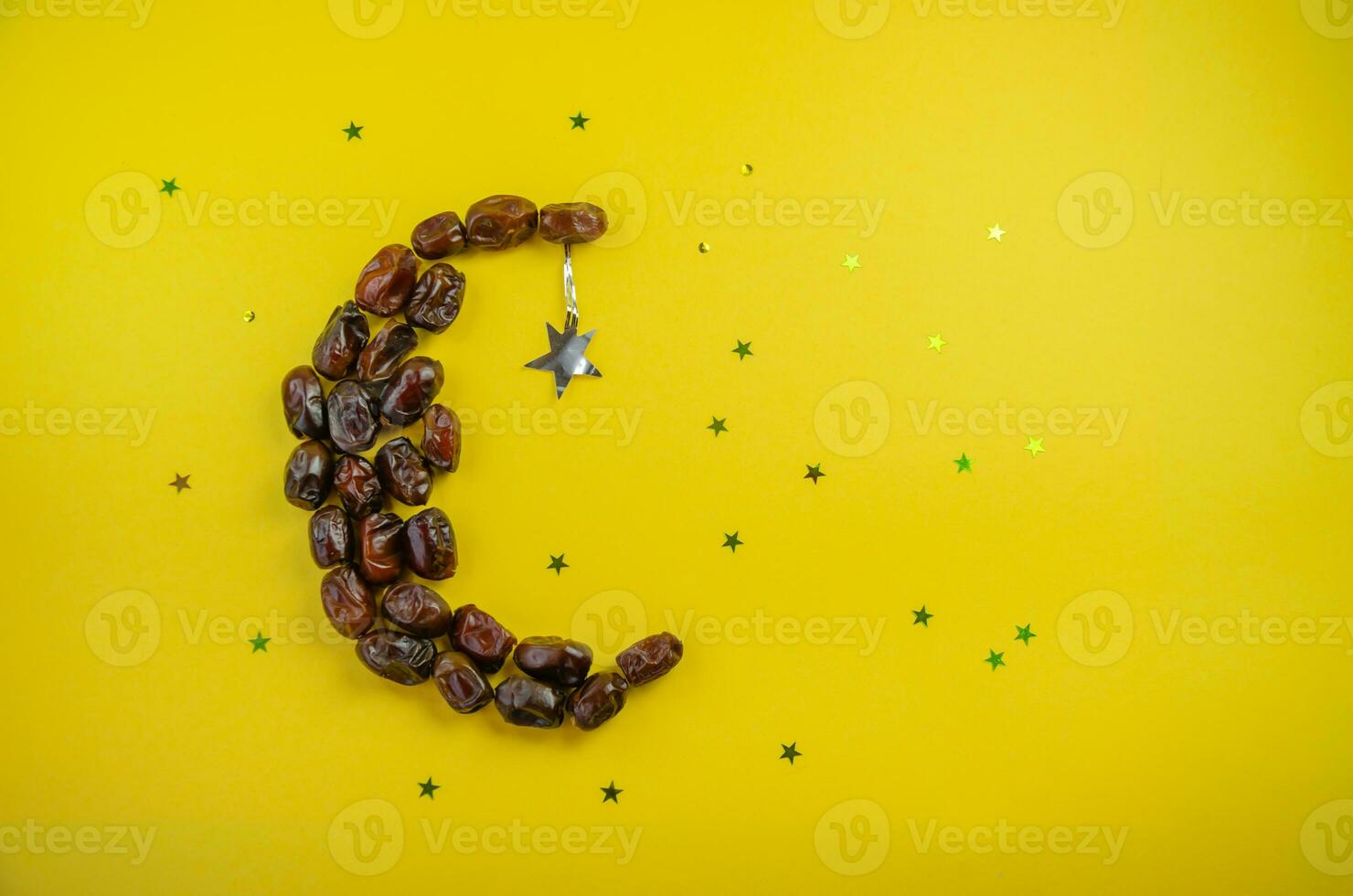 Ramadan holiday concept, on a yellow background of dates in the form of a moon with shiny stars. High quality photo