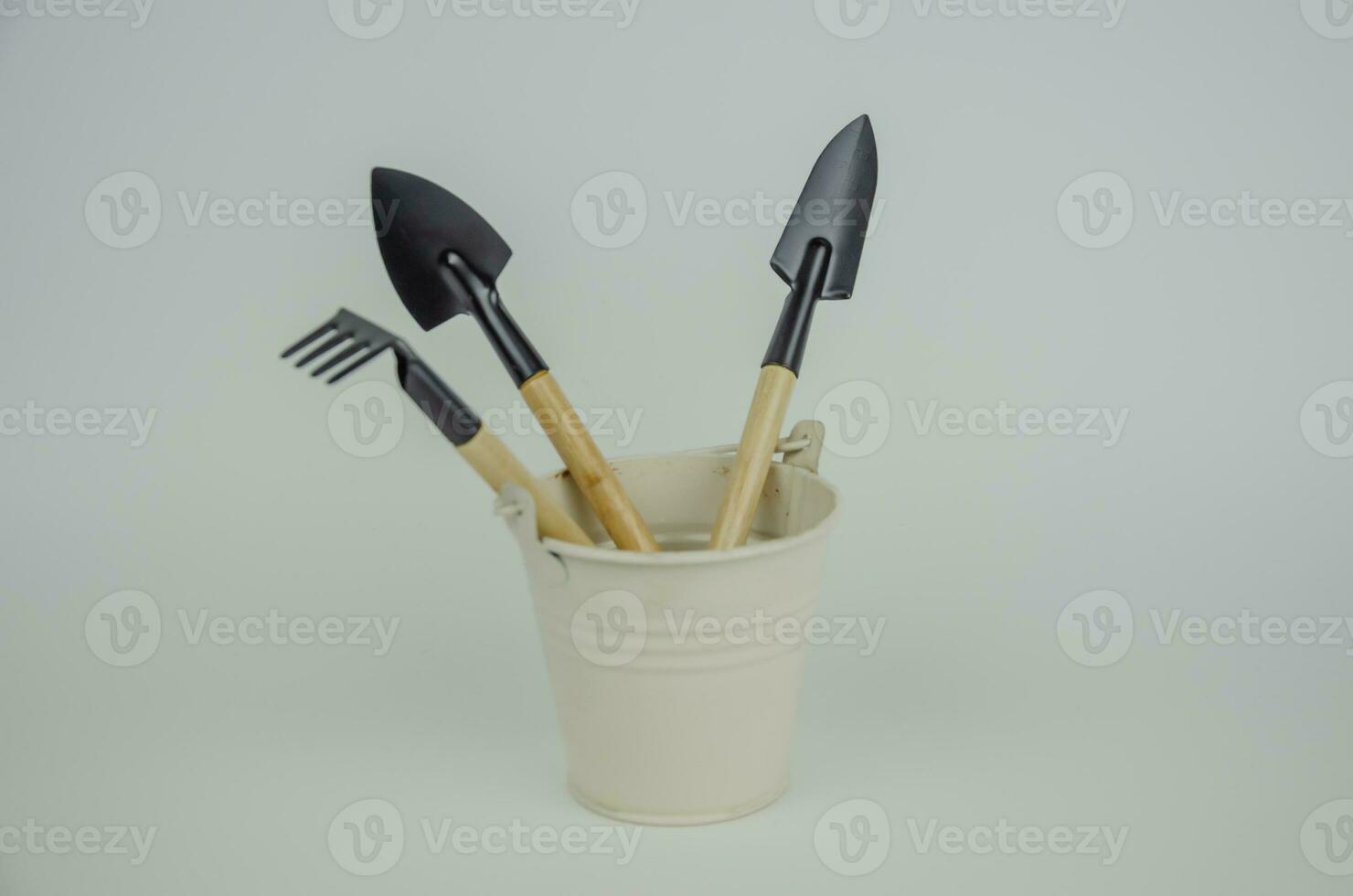 Garden tool in a white bucket on a light background photo
