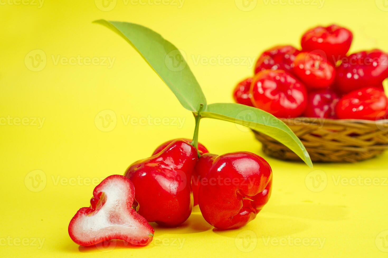 fresh water apple fruit and some water apple on basket behind on yellow background photo