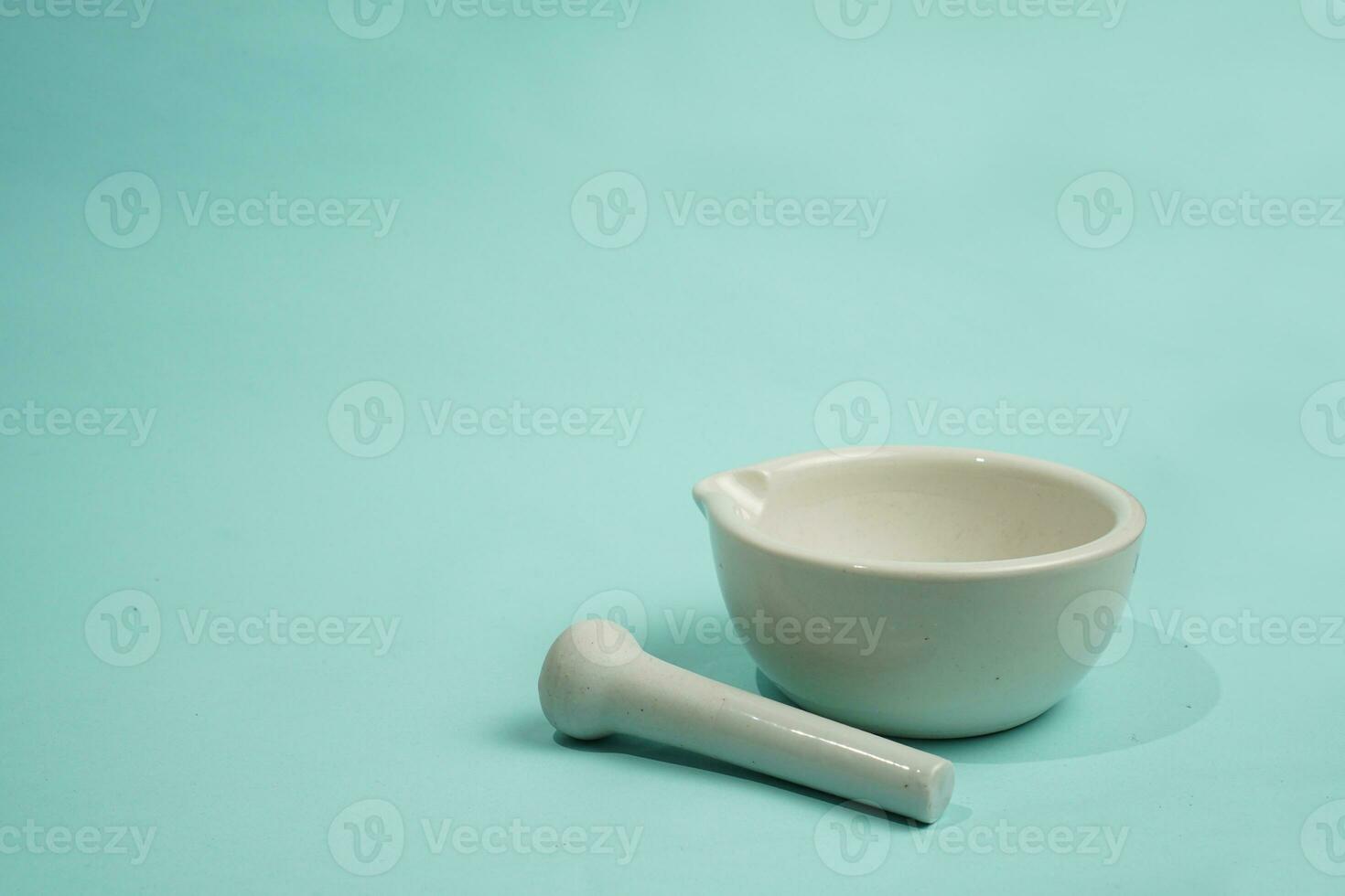 Mortar stamper in pharmacy  tools to mix ingredient for making medicine isolated on blue background photo